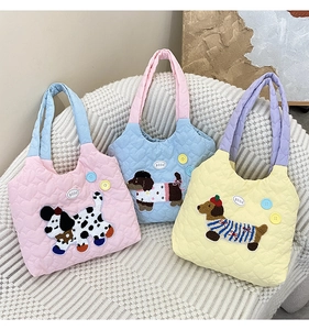 Detailed view of quilted cotton tote bags featuring colorful dog embroidery and heart textures