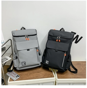 Detail view of large capacity gray and black backpacks with orange zipper accents