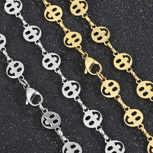 Macro shot of silver and gold stainless steel chains with hollow smiley face links