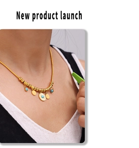 Detail of 18k gold plated snake chain necklace with turquoise beads and evil eye pendant