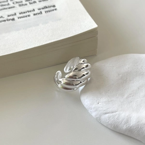 Minimalist sterling silver croissant ring with sleek textured stripes on a white background