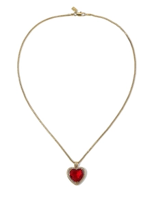 Detailed close-up of a gold necklace featuring a red heart gemstone with zircon halo