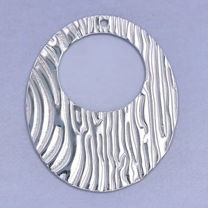 Macro shot of silver 304 stainless steel oval pendant featuring irregular textured finish
