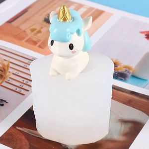 Detail view of unicorn silicone mold with finished resin ornament on a magazine background