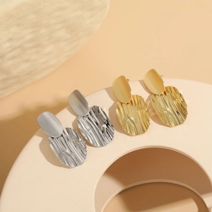 Detailed view of textured 14K gold and silver plated earrings with water ripple pattern