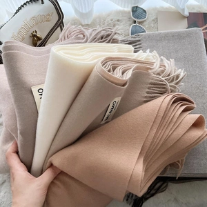 Soft faux cashmere scarf for women in neutral tones with tassels and brand label
