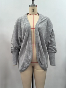 Dettaglio del cardigan grigio a maglia con strisce orizzontali e polsini lunghi a coste