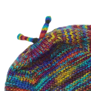 Detail of rainbow gradient knit beanie showing colorful wavy patterns and top braids