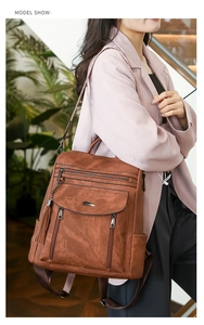 Brown vintage PU leather backpack with fringe detail and multi-zipper pockets on model