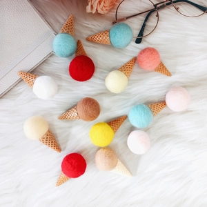 DIY colorful wool felt ice cream cone accessories on a soft white plush background