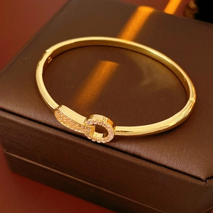 Close-up of gold-plated bangle with pavé zircon clasp on premium leather display box