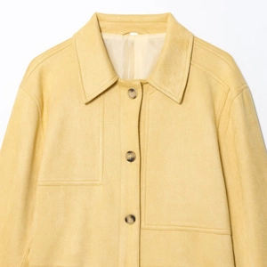 Minimalist yellow faux suede jacket with lapel collar and dark tortoiseshell buttons