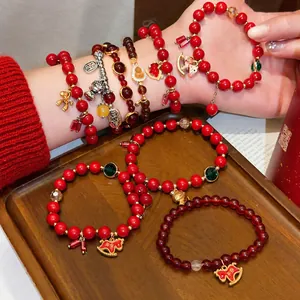 Traditionelle rote Achat-Perlenarmbänder mit verheißungsvollen Goldanhängern für Glück