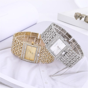 Luxurious square quartz watches with rhinestones in gold and silver on white fabric