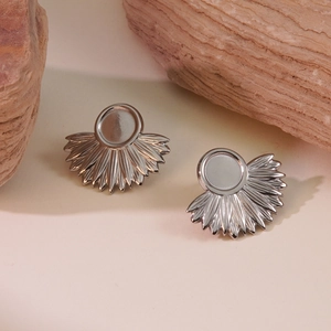 Artistic silver fan-shaped sunburst earrings on natural stone background scene