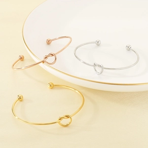 Minimalist knot cuff bracelets in gold, silver, and rose gold with polished finish