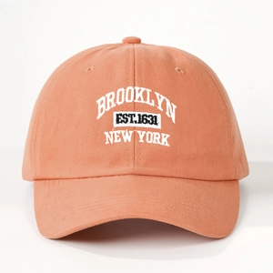 Detail of coral orange cotton baseball cap with white Brooklyn New York embroidery