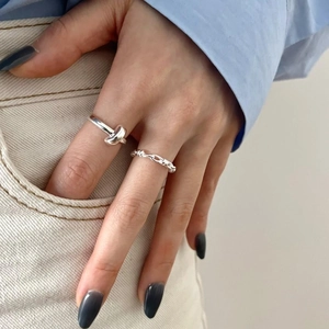 Detailed view of 925 sterling silver braided and knotted ring set on a model