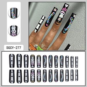 Faux ongles longs carrés pour Halloween avec motifs de crânes colorés sur fond noir