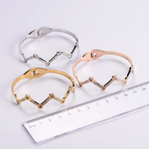 Close-up of crown-shaped diamond bangles in gold, rose gold, and silver finishes