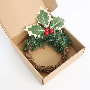 Gros plan d'une couronne de Noël avec baies rouges et aiguilles de pin dans une boîte