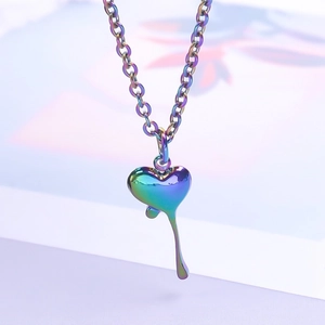 Macro shot of colorful iridescent stainless steel liquid heart pendant on a chain