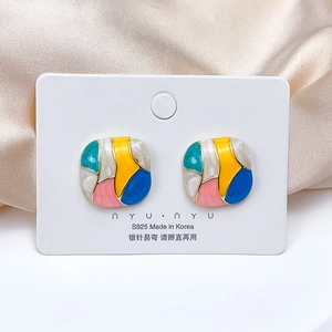 Detailed macro view of S925 silver colorful enamel floral earrings on white card