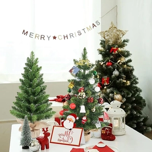 Close-up of 60cm tabletop Christmas trees with ornaments and rustic burlap base