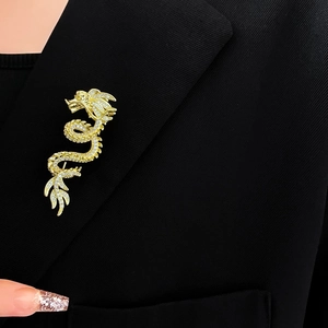 Macro detail of a gold-plated dragon brooch with sparkling crystals on a black suit lapel