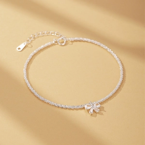 Close-up of S925 silver bracelet featuring a sparkling bow charm with moonstone accents