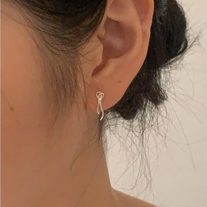 Close-up of minimalist 925 sterling silver bow knot stud earrings on a female model's ear