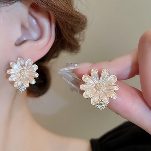 Elegant white daisy flower earrings with gold center and sparkling cubic zirconia stones