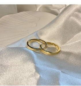 Macro shot of gold S925 sterling silver hoop earrings on a white silk background