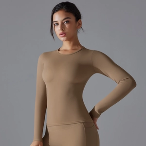 Detail of slim fit long sleeve yoga top featuring elastic stretch fabric in coffee brown