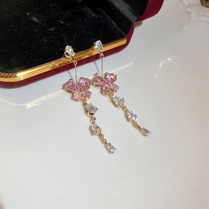 Detail of pink butterfly earrings with sparkling cubic zirconia tassels on a ceramic plate