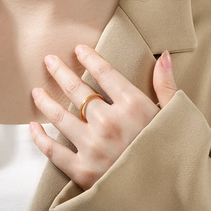 Nahaufnahme eines minimalistischen, mattierten 18K vergoldeten Edelstahlrings am Finger