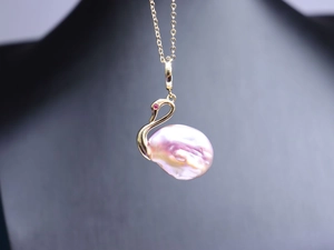 Vue macro détaillée du pendentif cygne avec perle baroque rose et placage en or fin