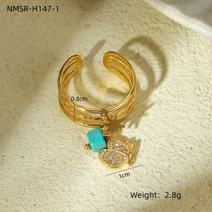 Detail of gold layered ring with butterfly pendant, star, and green stone charms