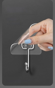 Detail of transparent adhesive hook showing the peeling of the protective film by hand