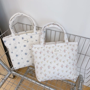 Quilted floral cotton handbags with light patterns in a silver shopping cart