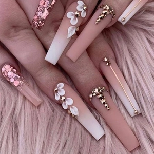 Macro detail of long ballerina nails with pink gradient, white flowers and gold rhinestones