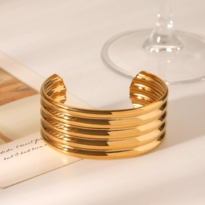 Polished 18K gold-plated multilayer ribbed cuff bracelet in a luxury scene