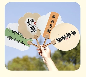 Detail of Chinese calligraphy paper fans with auspicious text held against the blue sky