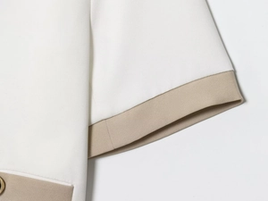Detail of white blazer stitching with beige contrast trim and high-quality woven fabric