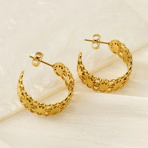 Gold-plated hollow C-shaped earrings with geometric patterns on elegant white porcelain