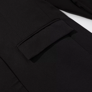 Dettaglio della tasca laterale su un blazer nero con trama di tessuto raffinata