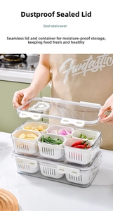 Detail of transparent partitioned food container with white drainage baskets and sealing lid