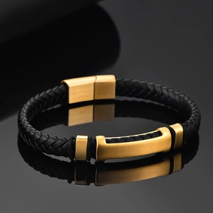 Detail of woven black leather bracelet with gold brushed stainless steel metal clasp
