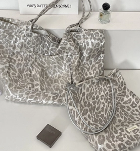 Close-up of metallic leopard print tote bag with reinforced handles and silver finish