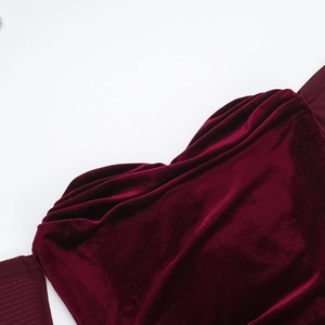 Detail of burgundy velvet dress showing the premium ruched texture and soft luster fabric